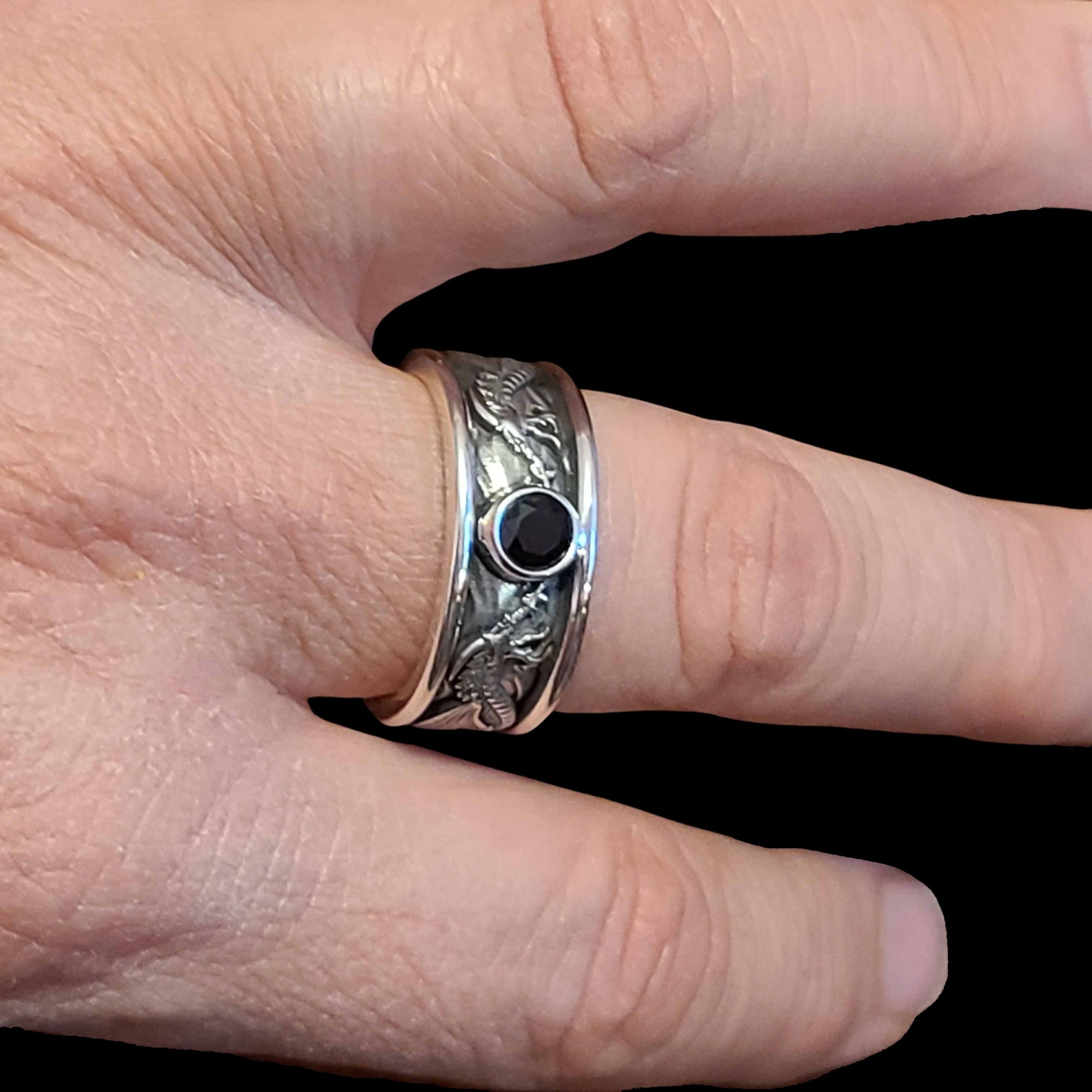 This Ring is hand crafted out of Sterling Silver and it store is a size 9 with a 16 mm Dragon Vein Agate neat design band